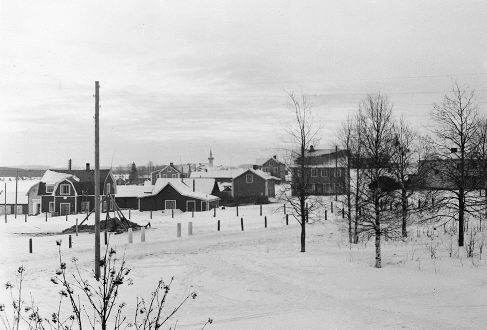 Pajala kyrkby med kyrkan längst i bakgrunden och närmast telegrafstationen, prästgården och andelsmejeriet.